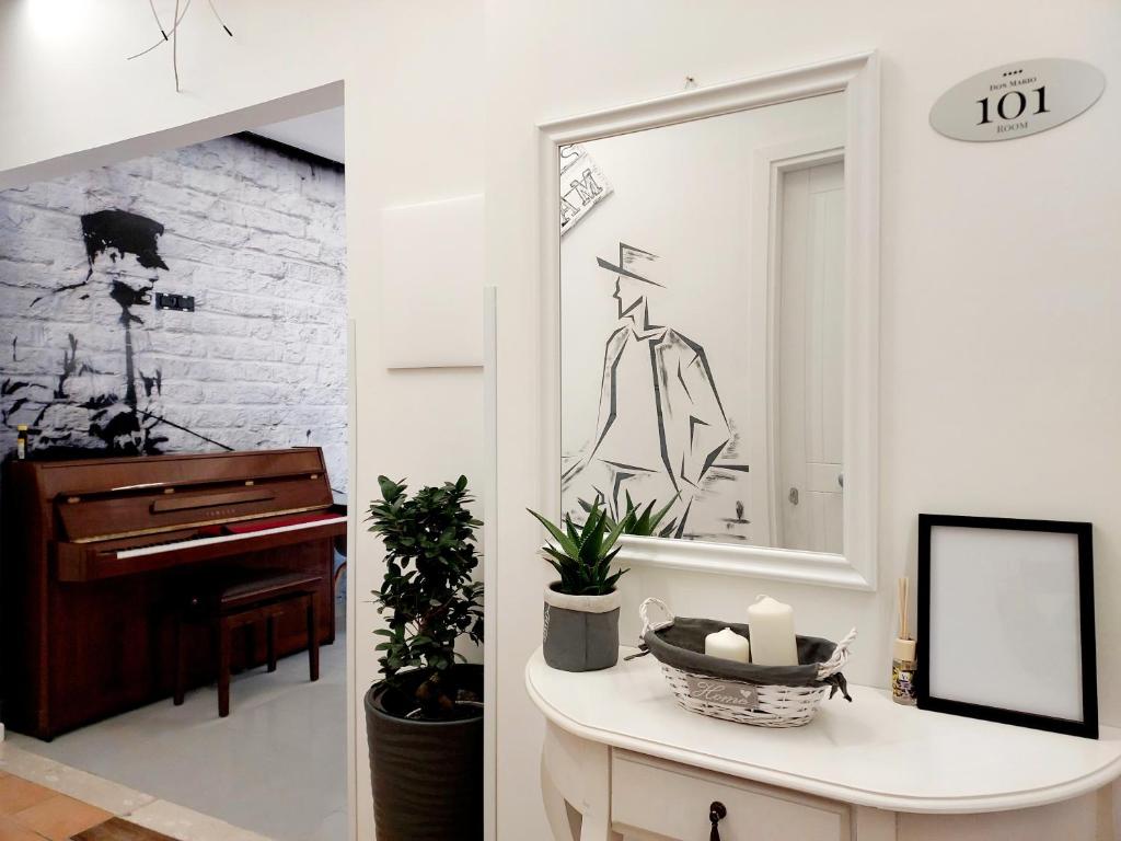 卡梅罗塔码头Don Mario Aparthotel & Rooms的客厅配有镜子和钢琴