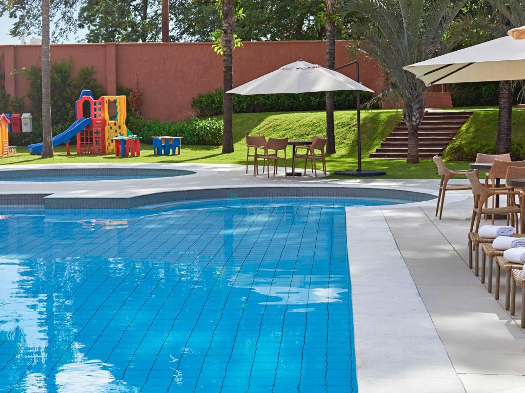 大坎普大坎普诺富特坎酒店的一个带椅子的游泳池和游乐场