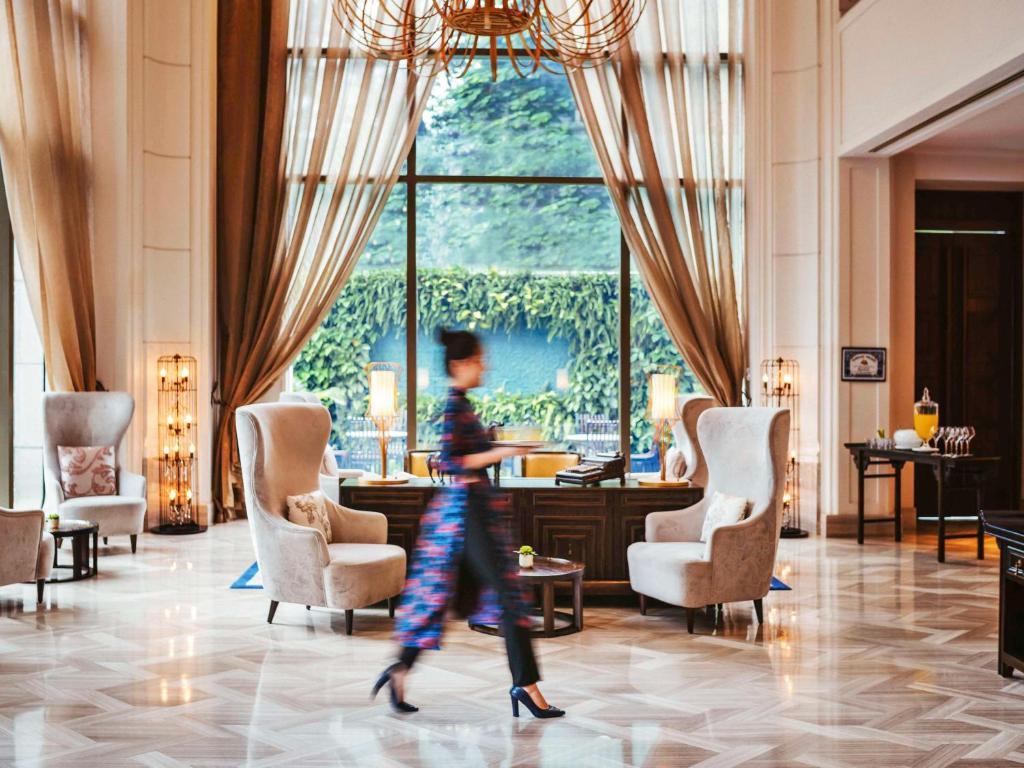 胡志明市西贡美憬阁艺术酒店的一位妇女穿过酒店的大堂