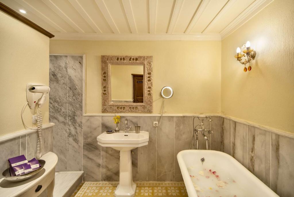 塞尔丘克古卢卡那克拉利酒店的浴室配有盥洗盆和浴缸。