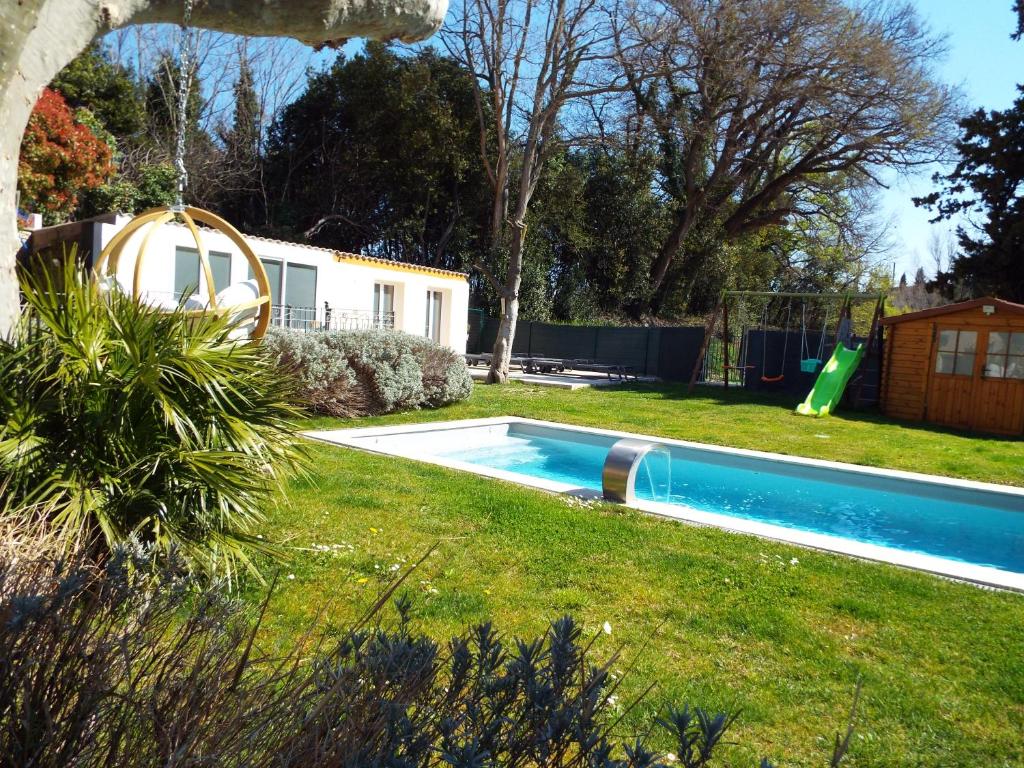 阿维尼翁Gîte de Fanny du Moulin de Tartay en Avignon的一个带游乐场的庭院内的游泳池