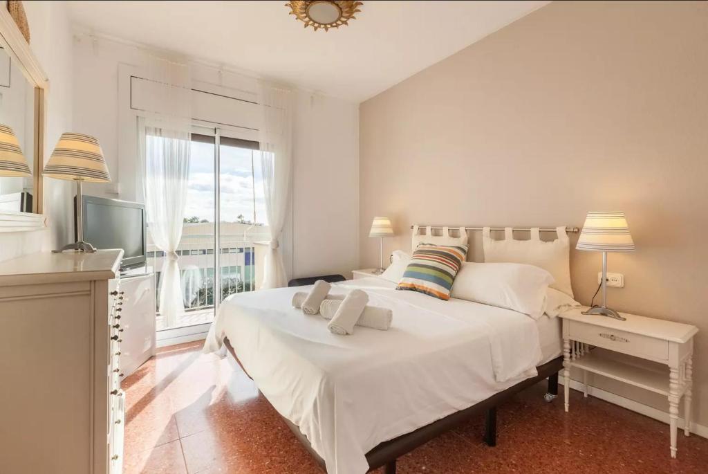 滨海比拉萨尔Apartment Muralla的卧室配有一张白色大床和电视。