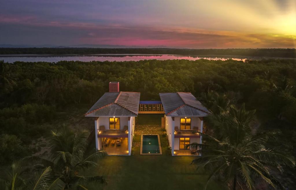 坦加拉Sati Villa Rekawa Beach Sri Lanka的享有房屋的空中美景和日落美景