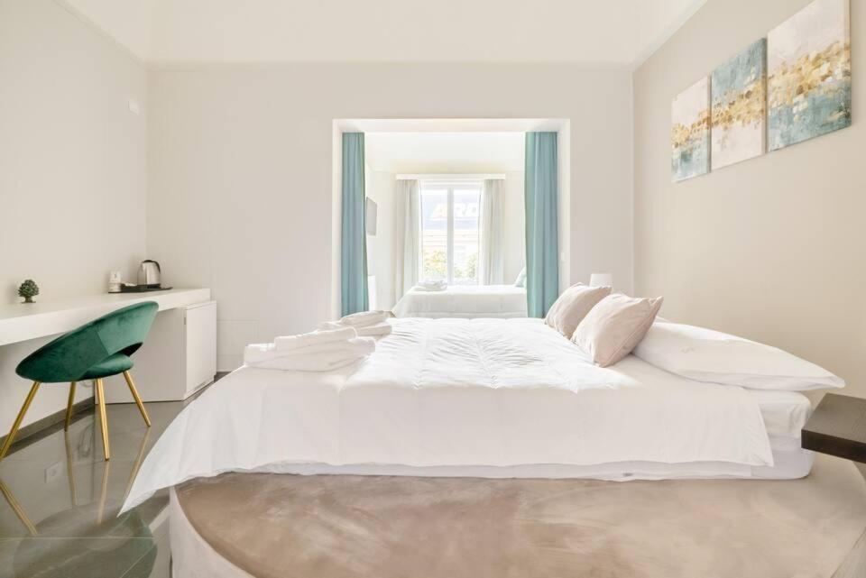马尔萨拉Shoruq的白色卧室设有一张大床和一把绿色椅子