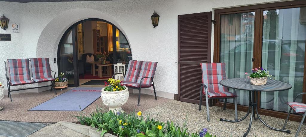巴特特尔茨阿尔卑藿夫酒店的庭院设有两把椅子、一张桌子和一扇窗户。