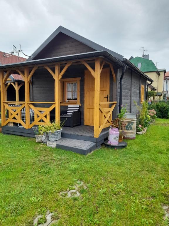 梅尔诺Mielno - Kwiatowy Zakątek #2的小木屋设有门廊和庭院