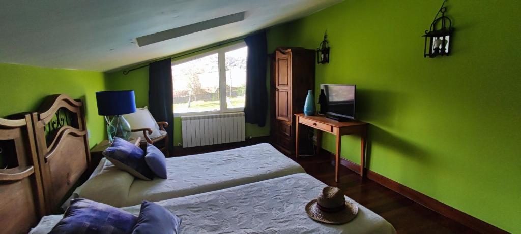 阿穆里奥casa rural usko的绿色客房配有两张床和电视。