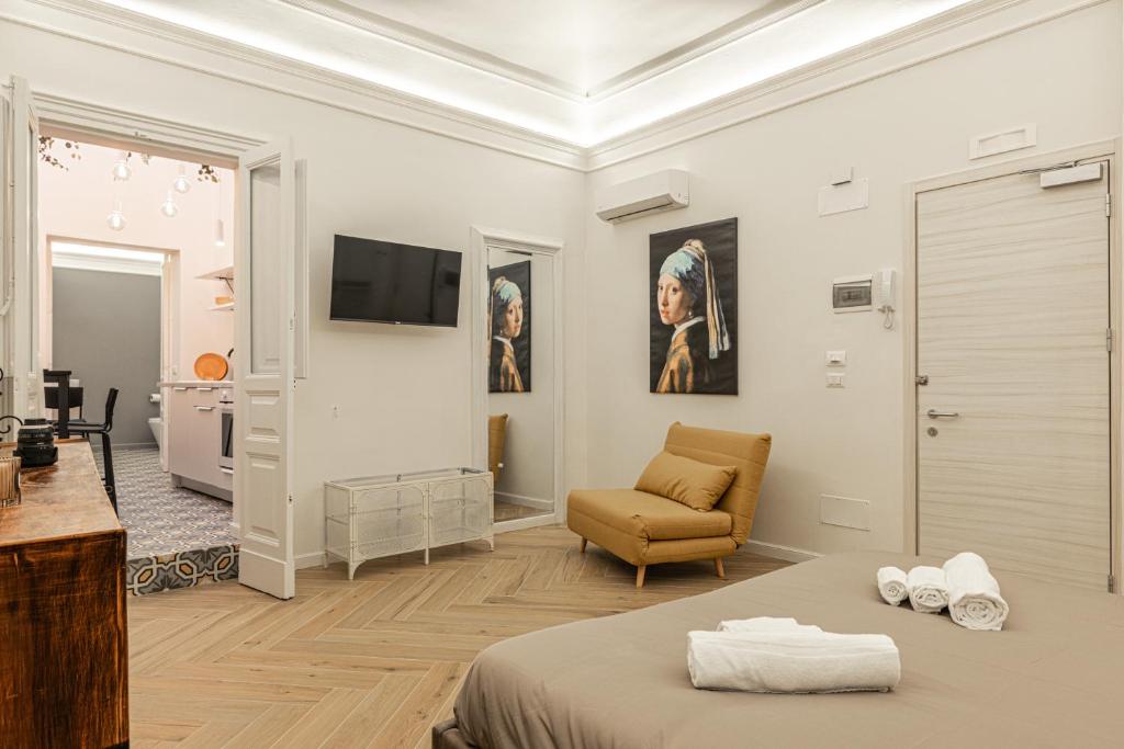 卡塔尼亚Residenze Florio的一间卧室配有一张床、一张沙发和一台电视