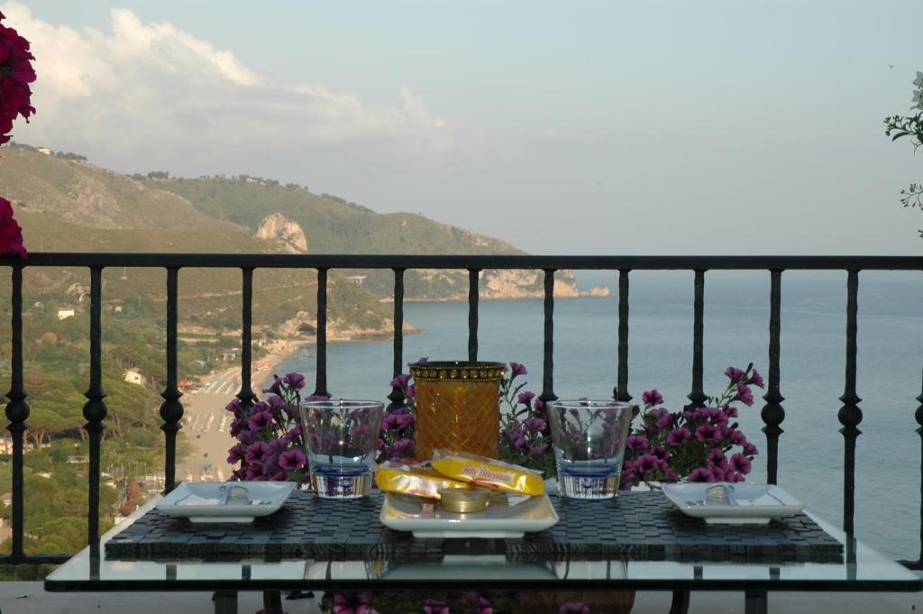 斯佩隆加Hotel Corallo Sperlonga的阳台上配有带食物和眼镜的桌子