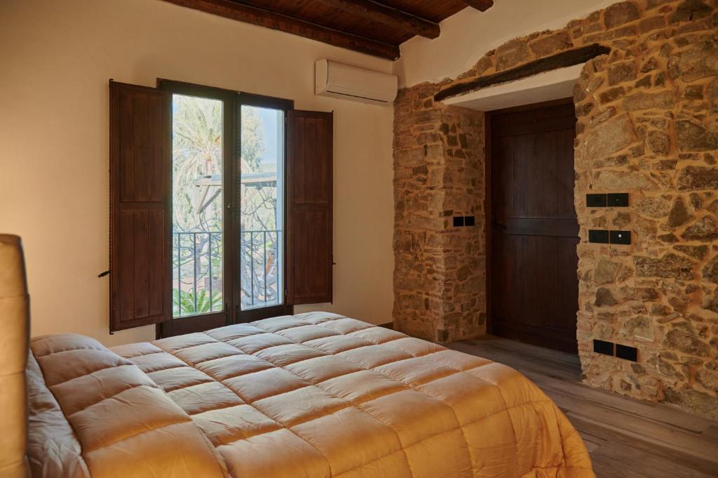 波利纳特努塔罗戈马尔凯塞乡村民宿的一间卧室设有一张大床和石墙