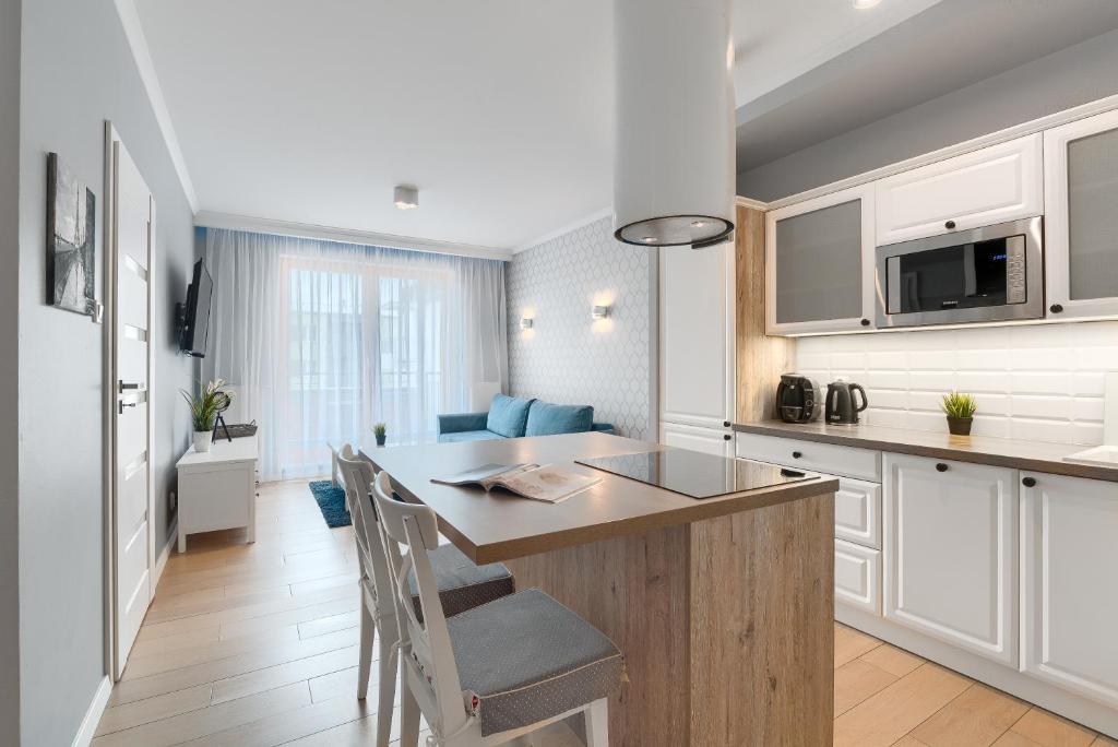什切青EXCLUSIVE New Town Apartments的一间厨房,配有白色橱柜和一个带台面的岛屿