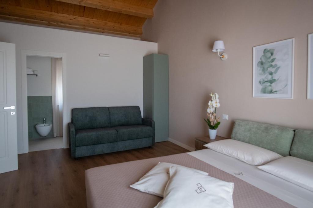 圣马蒂诺－因彭西利斯Dimora Donna Dora - Albergo Diffuso的一间卧室配有一张床和一张绿色沙发