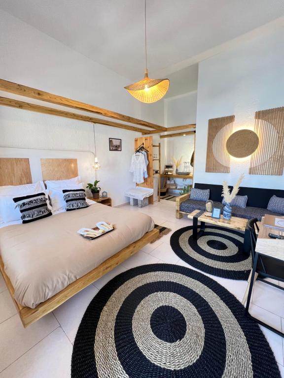 卡利诺岛Spongia Apartments Kalymnos的一间卧室配有一张大床和一张沙发