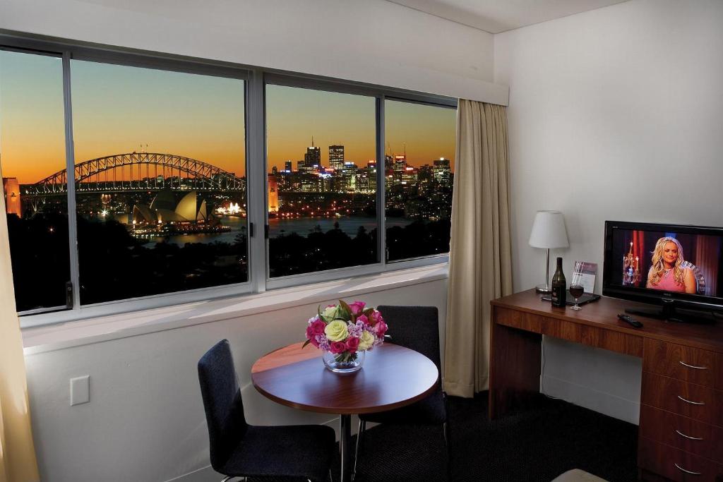 悉尼马克利公寓酒店的酒店的客房,配有书桌和鲜花桌