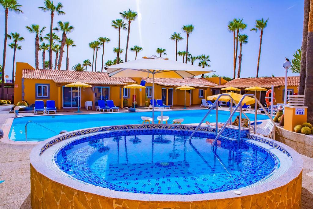 英格兰海滩Bungalows Los Almendros - Exclusive Vacation Club的棕榈树度假村的游泳池