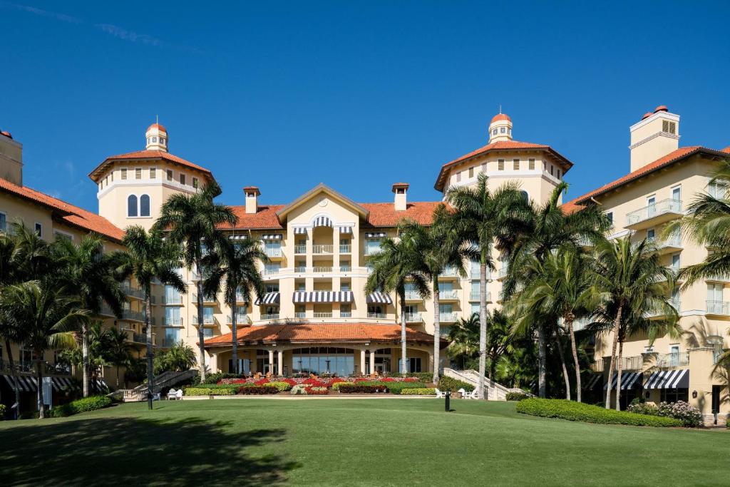 那不勒斯The Ritz-Carlton Naples, Tiburon的一座棕榈树环绕的大建筑