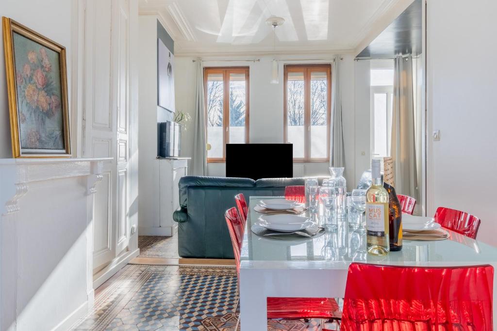 亚眠Maison Famille-Confort-Terrasse Jardin-Vue Cathédrale的一间带桌子和沙发的用餐室