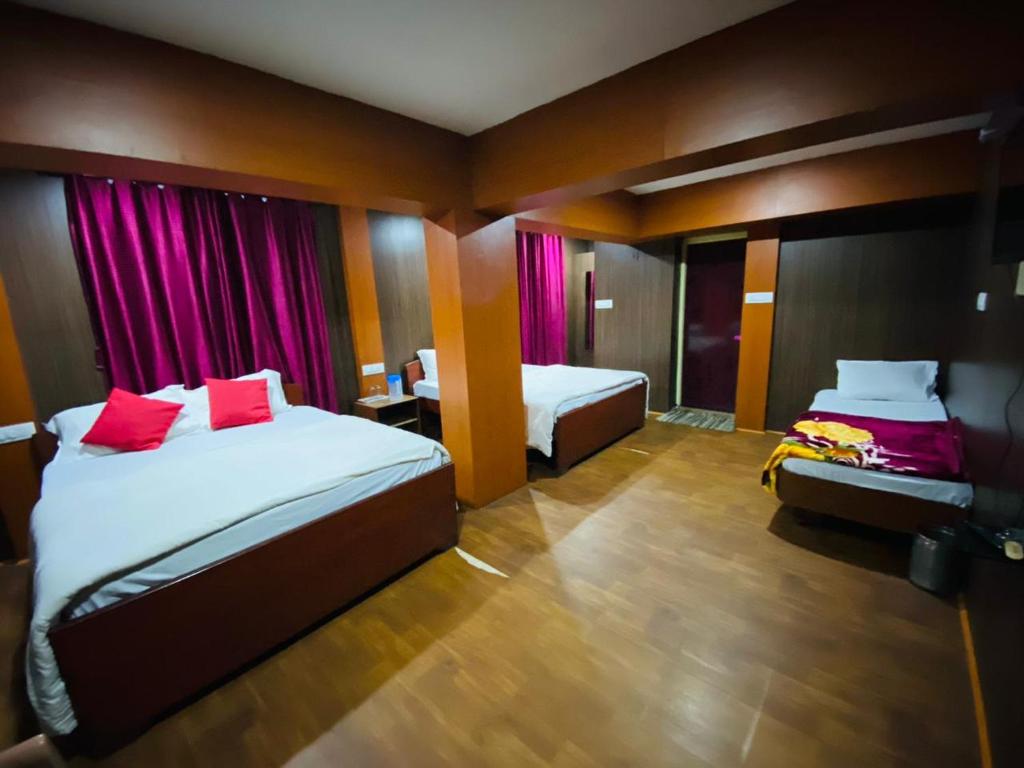 乌提Mananyaa Cottage的酒店客房 - 带两张带红色枕头的床