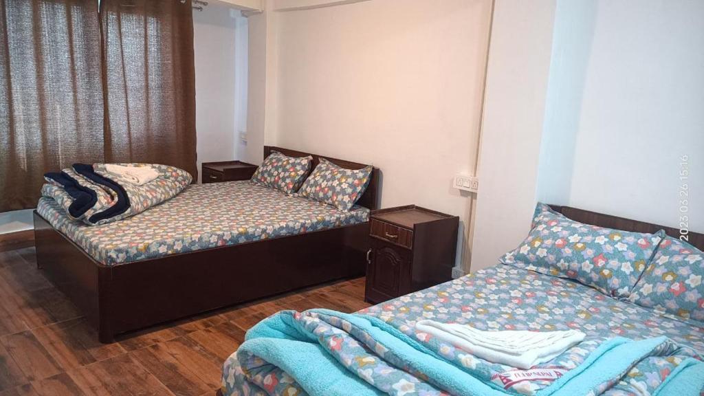大吉岭Darjeeling Homestay Nyano Ghar的一间设有两张床和一张沙发的房间