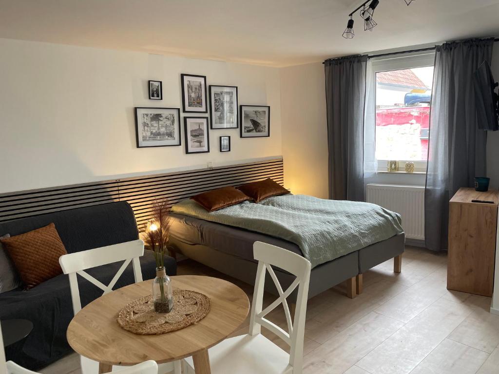 哈斯洛赫Freigeist Apartments的一间卧室配有一张床、一张桌子和一张沙发