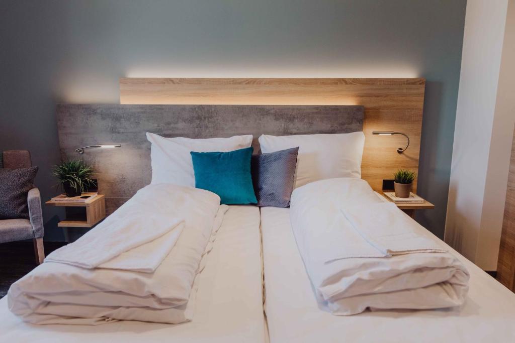 默尔斯多夫Pascals Ruhestube的一张配有白色床单和蓝色枕头的大床