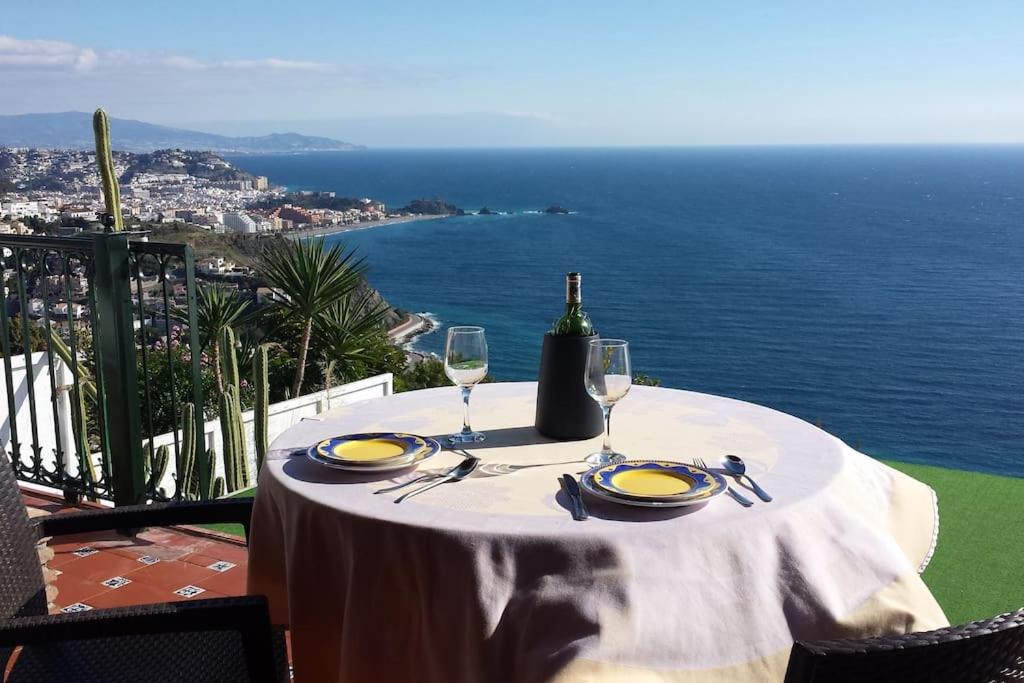 格拉纳达Blue Horizon Apartment的一张桌子,上面放着一瓶葡萄酒和两杯酒