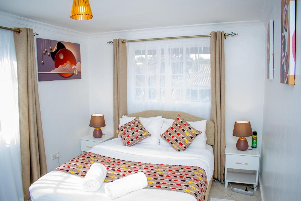 卡伦16 Arabella Residence near Waterfront Mall - Karen的一间卧室配有带色彩缤纷枕头的床