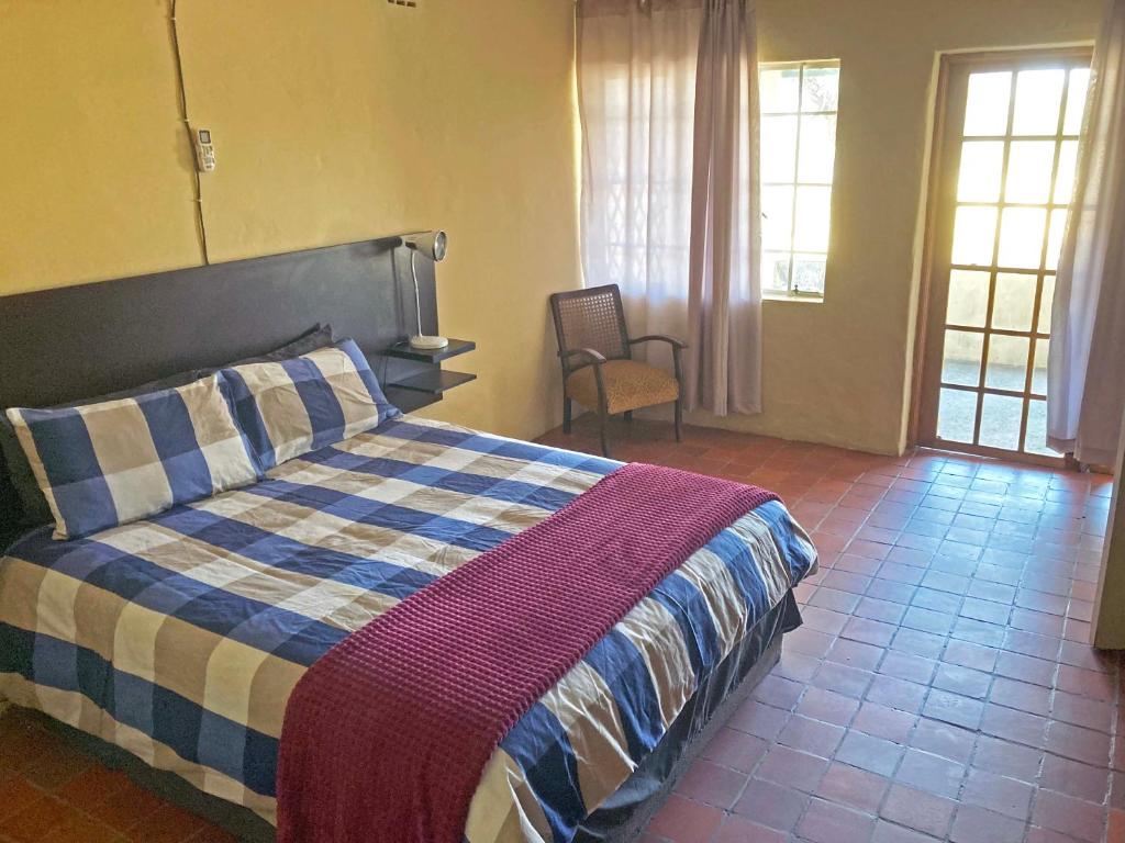 KhemsbokKalahari Homestead的一间卧室配有一张带蓝白色毯子的床