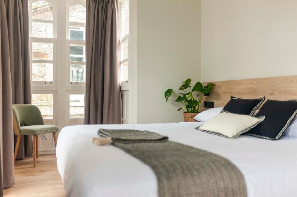 蓬特德乌梅Albatros的卧室配有白色床、椅子和窗户