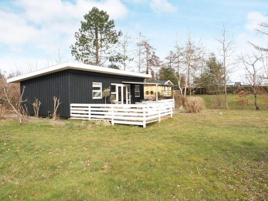 霍尔拜克Holiday home Holbæk III的田野上带白色围栏的黑色房子