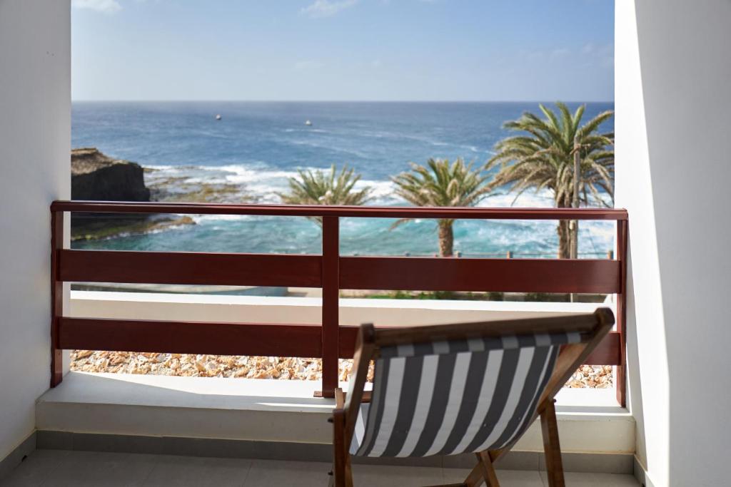 蓬塔杜索尔Música do Mar的一张长凳,坐在阳台上,眺望着大海