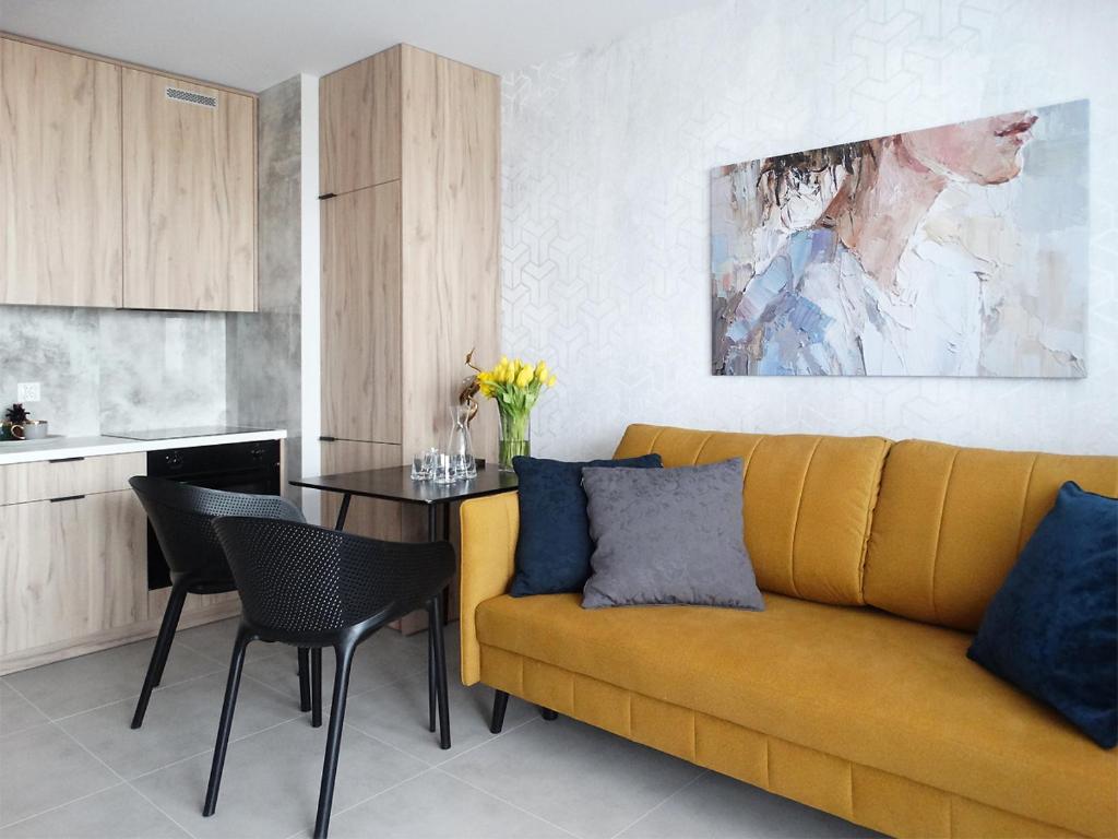 比亚韦斯托克Apartament Kraszewskiego的客厅配有黄色的沙发和桌子