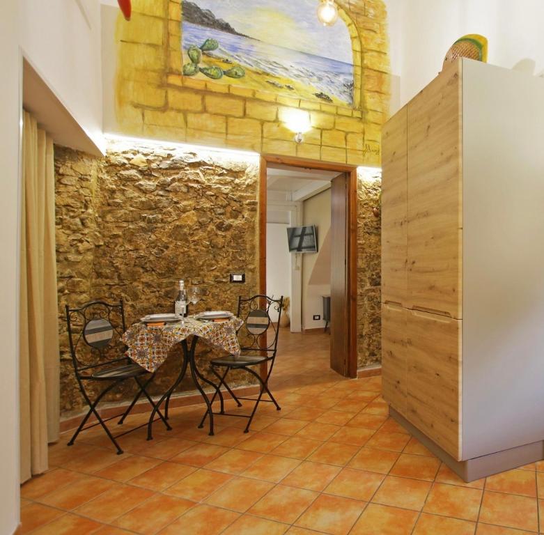 切法卢Antica Cefalu'的一间设有桌椅和石墙的用餐室