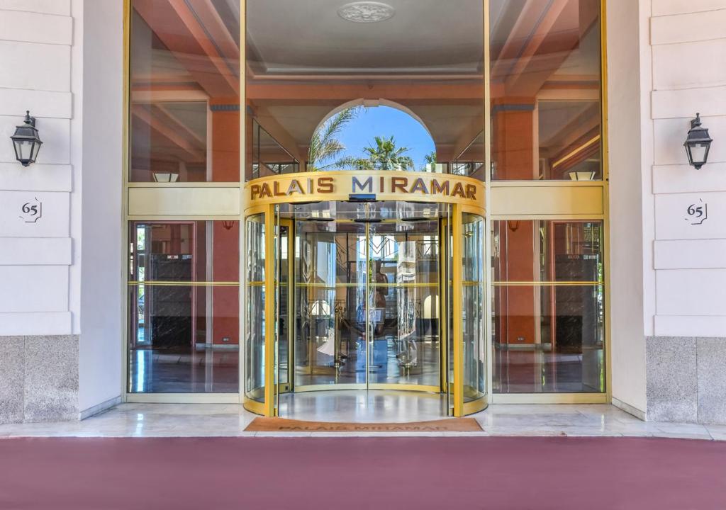 戛纳Croisette Palais Miramar Cannes Imperial的带有旋转门的建筑物入口