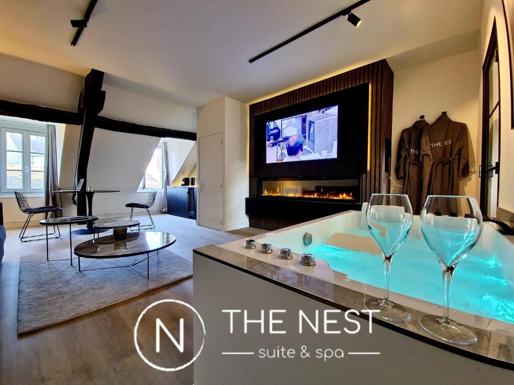 桑利斯The Nest. duplex jacuzzi hyper centre de Senlis的一间带浴缸和2杯酒的客厅