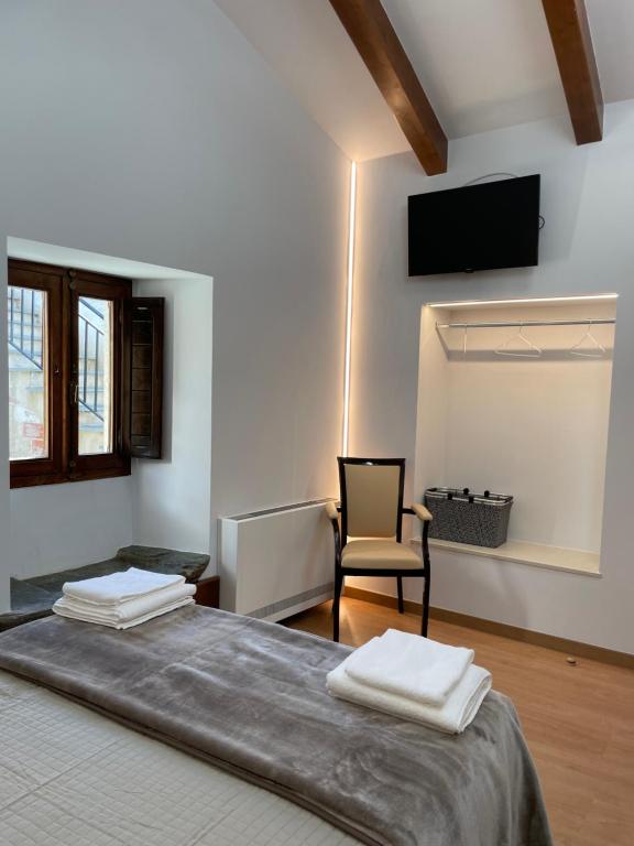 Hostal A Cantina de Renche的一间卧室配有一张带椅子的床和一台电视