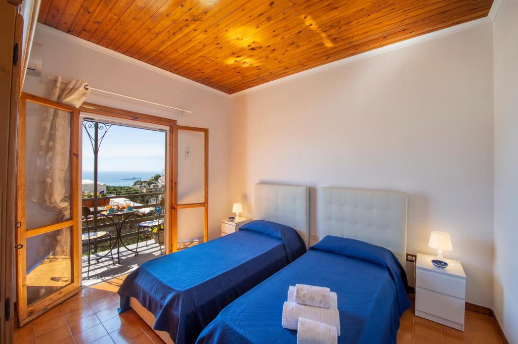 波西塔诺Casa la noce Positano的一间卧室设有蓝色的床和一个阳台