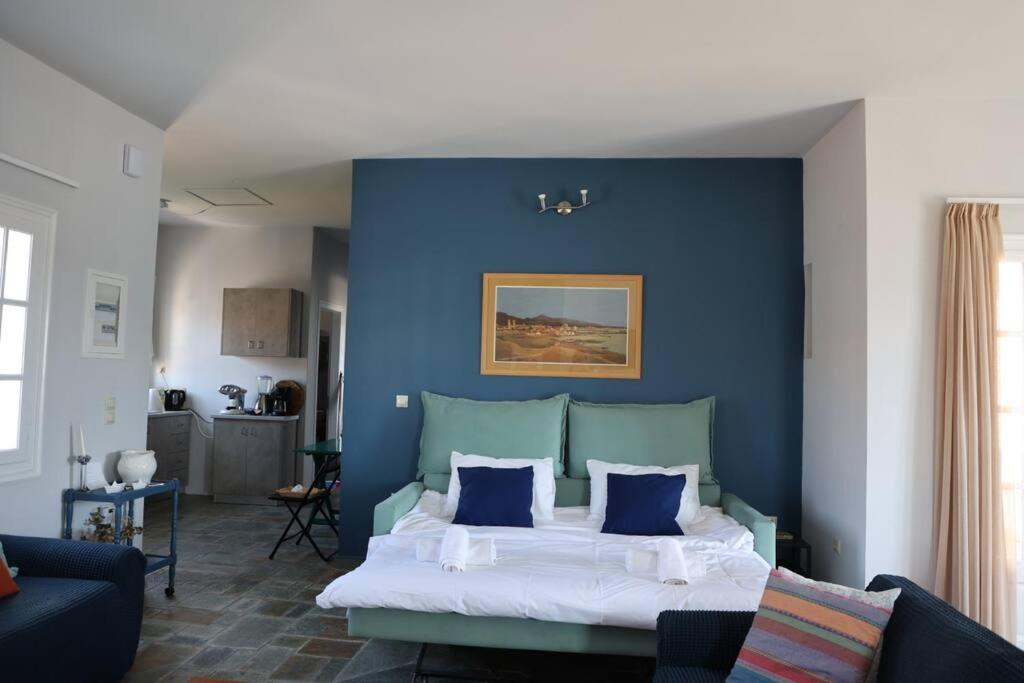 爱琴娜岛Psamathe Aegina Apartments的一间卧室设有蓝色的墙壁和床