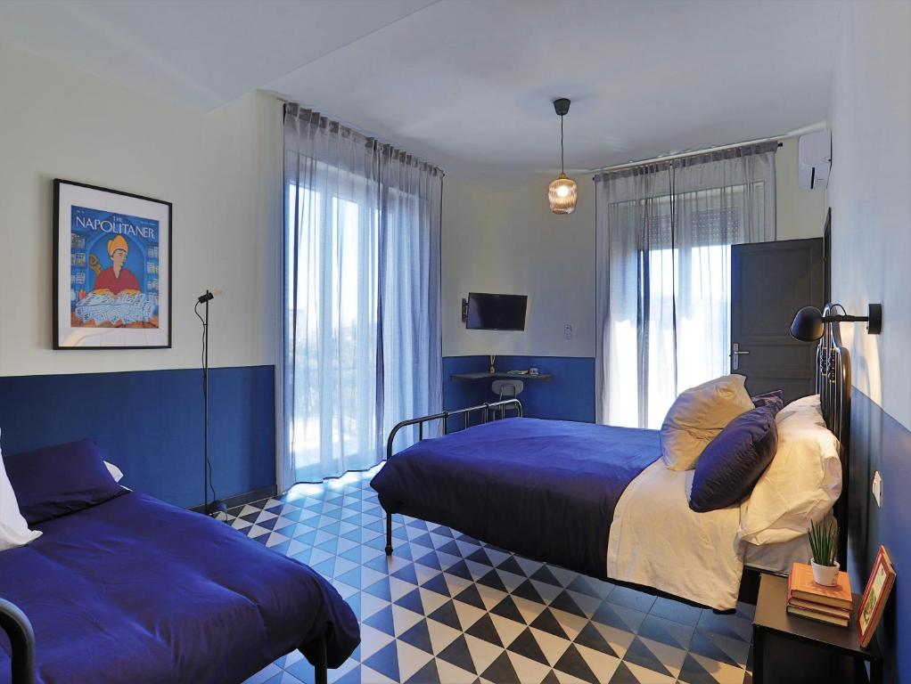 那不勒斯Nuccia Urban Loft的一间蓝色卧室,配有两张床和窗户