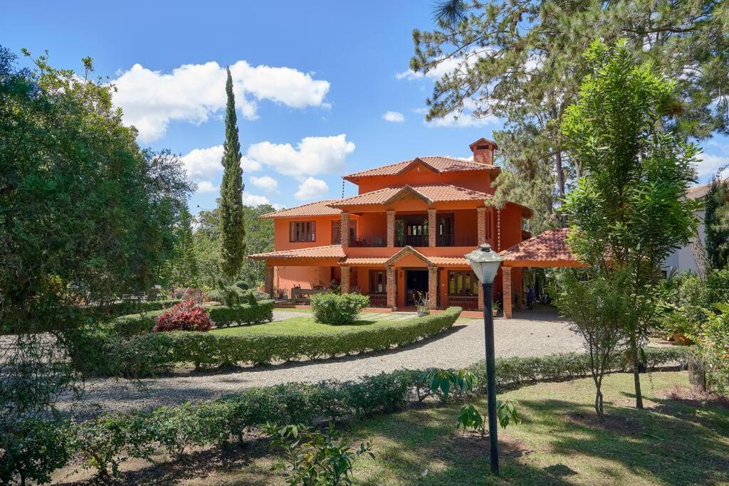 哈拉瓦科阿Fantastic Harmony Chalet in Pinar del Sol的一座大型橙色房子,前面设有花园