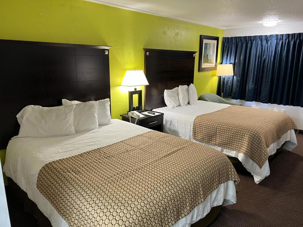 湖城漂流木汽车旅馆 - 湖城的两张床位于带黄色墙壁的酒店客房