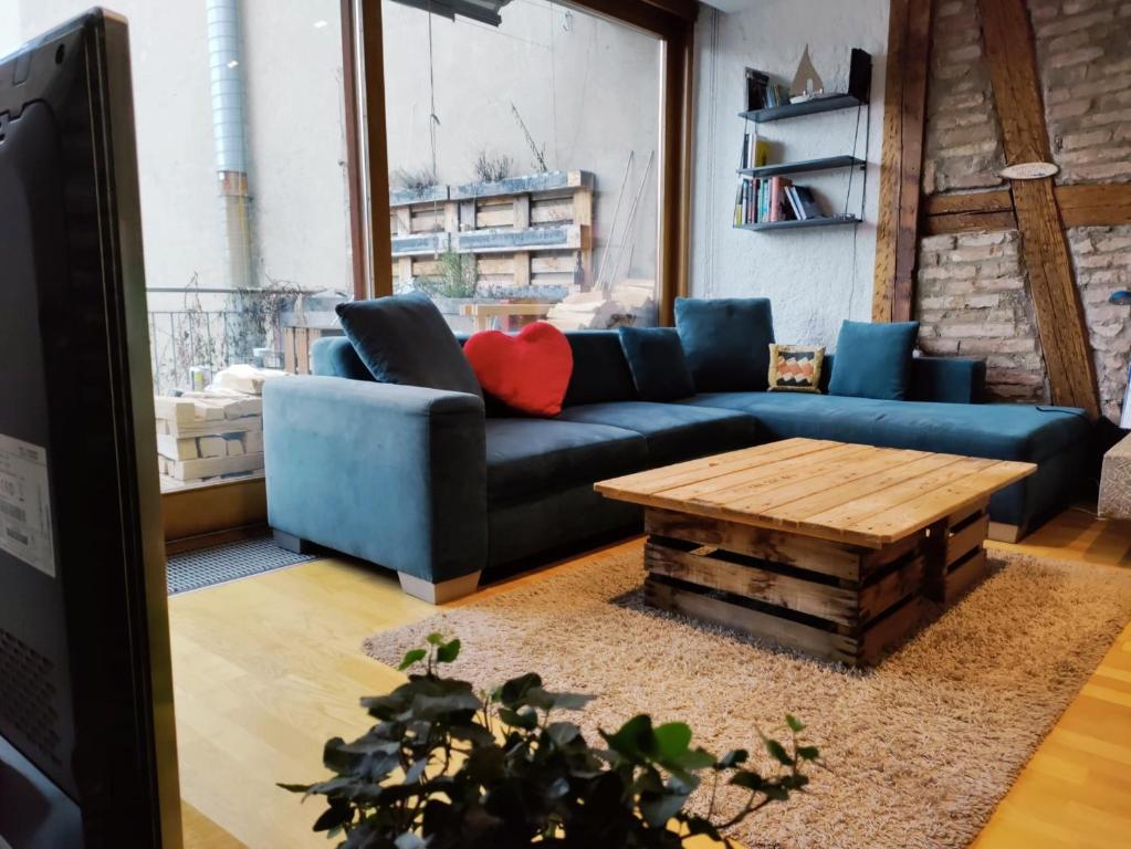 伯尔尼Central-city Penthouse的客厅配有蓝色的沙发和木桌