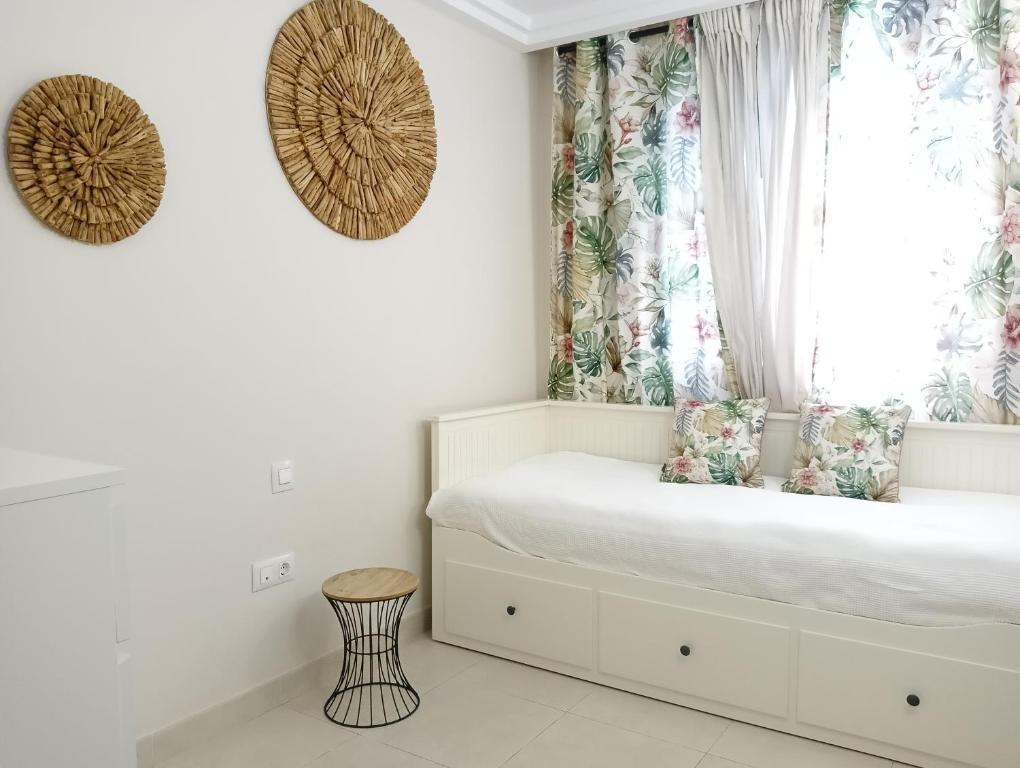 阿德耶Paula Pool Apartment Adeje的一间卧室配有一张带窗户和凳子的床