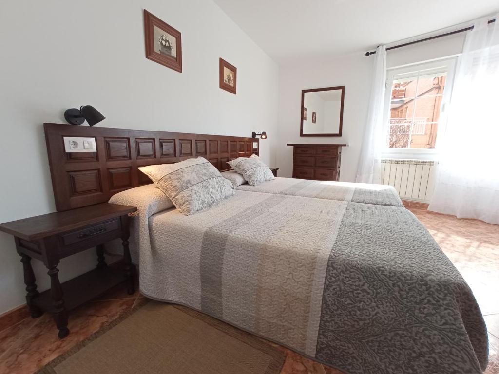 仕格莱EL RINCON DE LUISA Y SANTOS的一间卧室配有一张床、一张桌子和一个窗户。