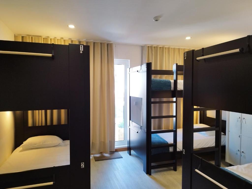 蓬塔德尔加达Santa Alegria Hostel的客房设有两张双层床和电视。