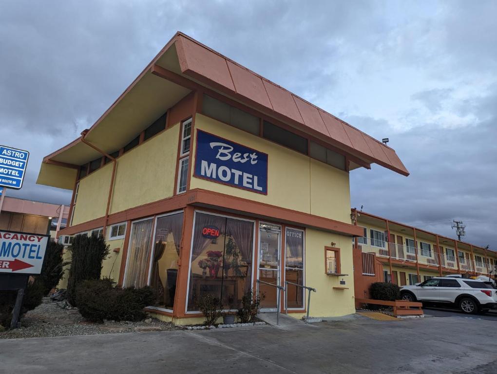 巴斯托BEST MOTEL的停车场里标有最佳汽车旅馆标志的商店