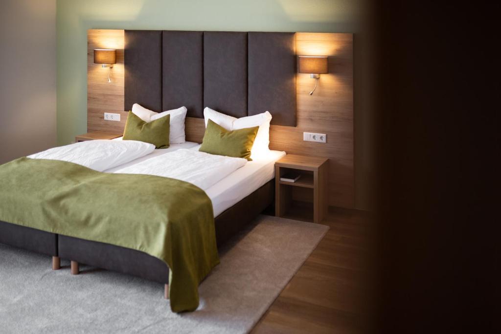 乌斯拉尔浪漫之旅酒店的卧室配有一张带绿床单和枕头的大床。