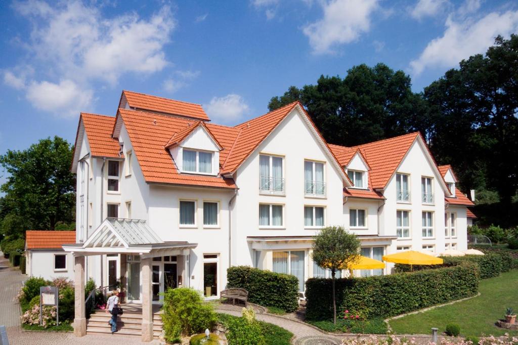 伊本比伦Hotel & Apartments Leugermann的一座白色的大房子,有橙色的屋顶