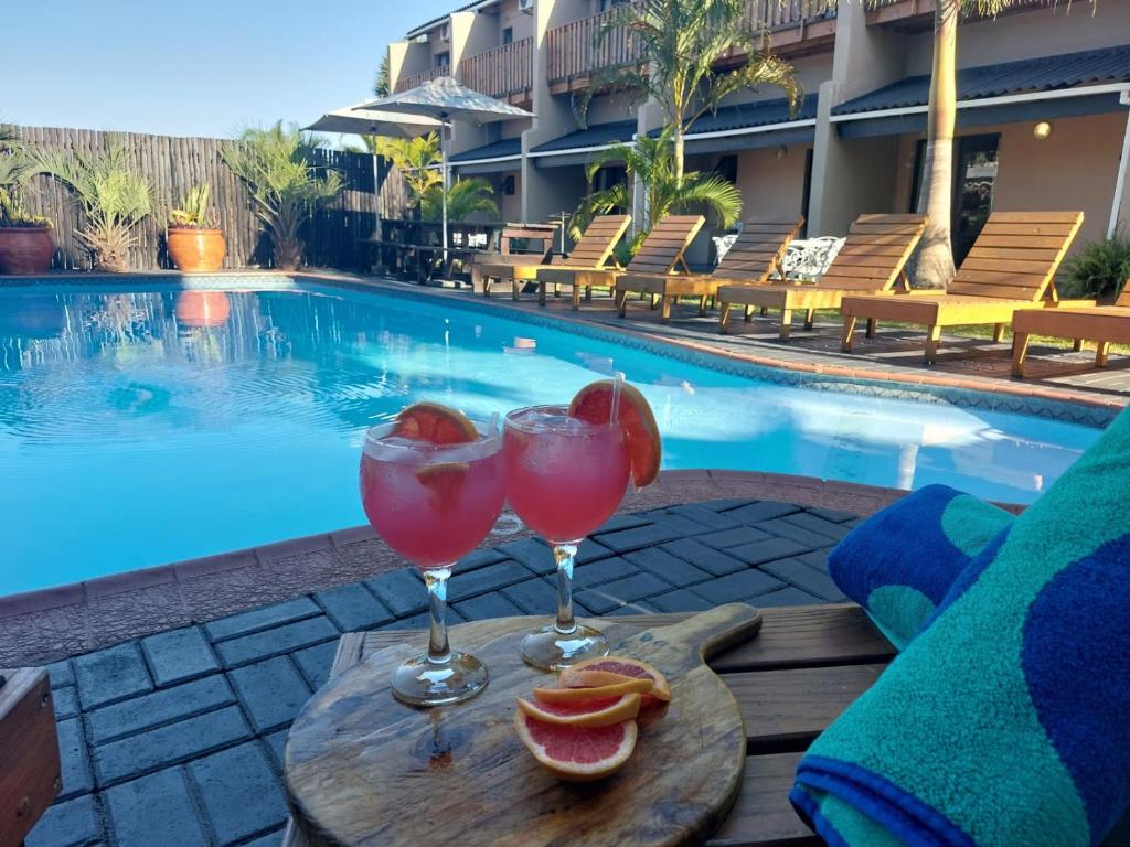 圣卢西亚St Lucia Lodge的游泳池畔的桌子上放上两杯酒