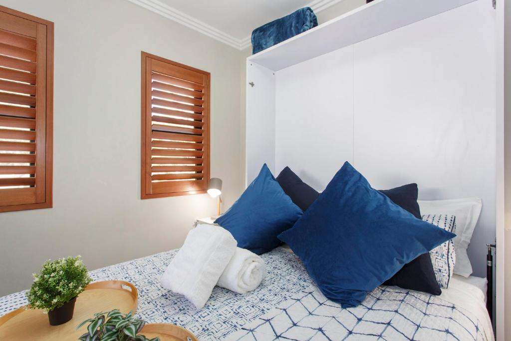 珀斯Bambino 438的一间卧室配有一张带蓝色枕头的床